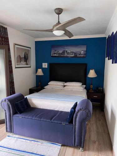 a bedroom with a large bed with a blue wall at 2 Op Terblanche Guesthouse in Boksburg