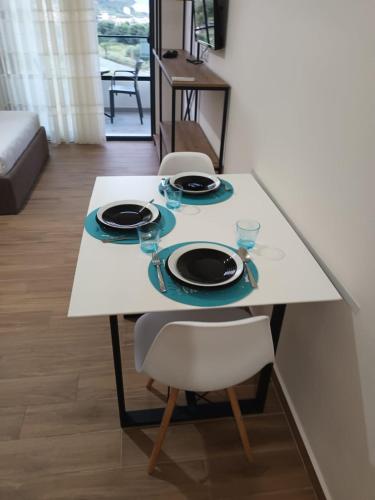 un tavolo con piatti e bicchieri sopra di Devi's Apartment a Vlorë