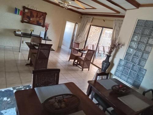 een eetkamer met tafels en stoelen in een kamer bij Kgatholoha guest house in Klerksdorp