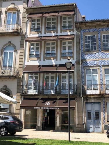 a building with two flags on the front of it at Hotel Senhora A Branca in Braga