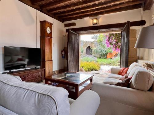 sala de estar con 2 sofás blancos y TV en Casagrande Don Pedro, en Cóbreces