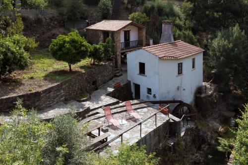 a small white house sitting on top of a hill at Encosta da serra do Bussaco Quintinha da Azenha in Penacova