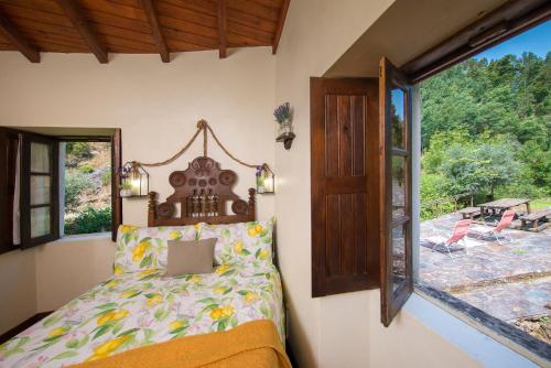a bedroom with a bed and a window at Encosta da serra do Bussaco Quintinha da Azenha in Penacova
