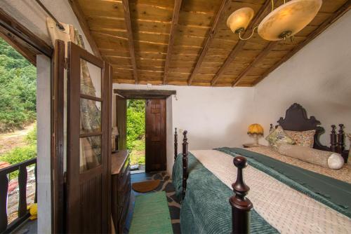 a bedroom with a bed and a wooden ceiling at Encosta da serra do Bussaco Quintinha da Azenha in Penacova