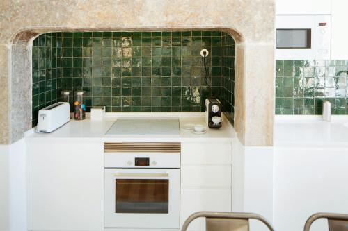 una cocina con encimeras blancas y una pared de azulejos verdes en Lisboa Se, TravelingtoLisbon 271 en Lisboa