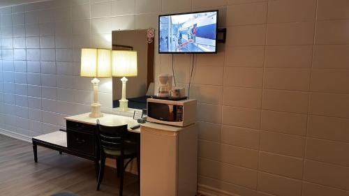 a room with a microwave and a tv on a wall at Bel-Air Motel in Sault Ste. Marie