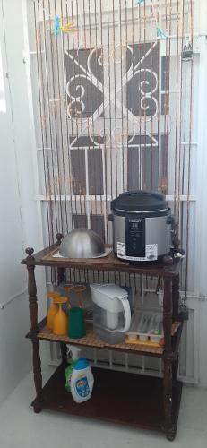 a bird cage with some food items on a shelf at Quiet Cottage in Residential Area in Montego Bay