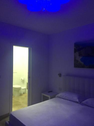 um quarto com uma cama e um tecto roxo em Garibaldi Rooms em Porto Cesareo