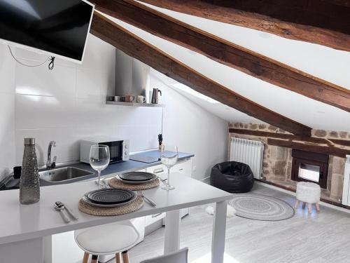 a kitchen with a table with wine glasses and a fireplace at Apartamentos Numancia in Garray