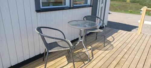 2 Stühle und ein Tisch auf einer Terrasse in der Unterkunft Hagi 2 Road 62 in Patreksfjörður