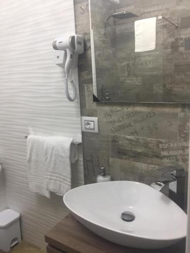 uma casa de banho com um lavatório branco e um espelho. em Garibaldi Rooms em Porto Cesareo