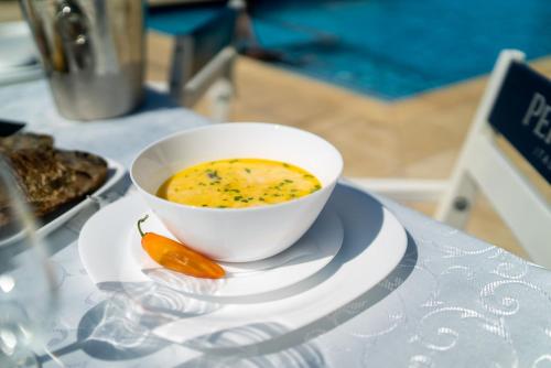 穆里吉奥尔Havana Resort的盘子里放着一碗汤和一根胡萝卜。