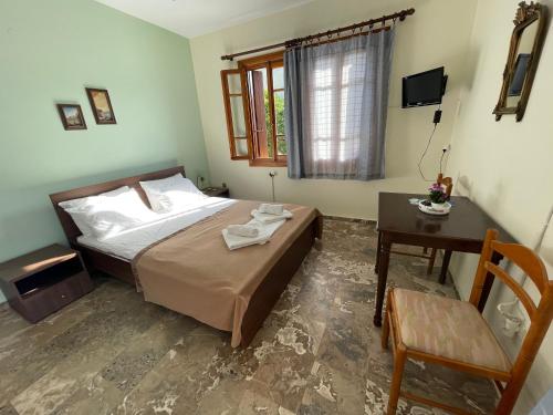 a bedroom with a bed and a table and a chair at Villa Apostolis Studios in Skopelos Town