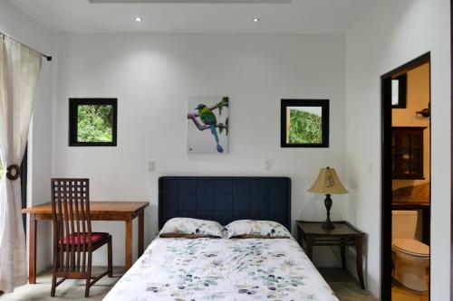 1 dormitorio con 1 cama, 1 mesa y 1 silla en Casitas Vista Verde en Bajo Boquete