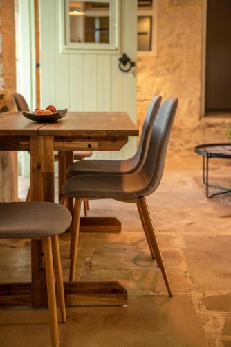 a wooden table with chairs and a bowl of fruit on it at Mourelo Home in Gavalochori