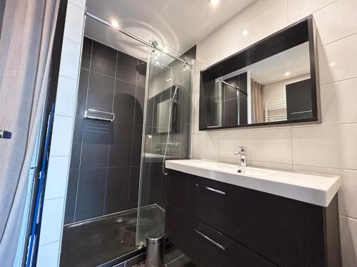 une salle de bain avec une douche, un lavabo et un miroir dans l'établissement Appartement de Prestige aux Gets - 4 Chambres, 10 Couchages, Proche Pistes et Centre - FR-1-623-66, aux Gets