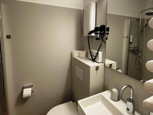 y baño con aseo, lavabo y espejo. en Discover Langeoog Comfortable apartment with SPA and pool en Langeoog