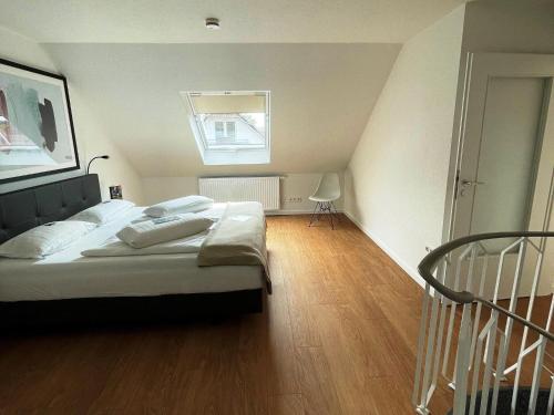 1 dormitorio con 1 cama grande y suelo de madera en Discover Langeoog Comfortable apartment with SPA and pool en Langeoog