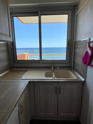d'une cuisine avec évier et d'une fenêtre avec vue sur la plage. dans l'établissement Appartement 4 pers Front de Mer - 10m de la Plage, à Saint-Raphaël