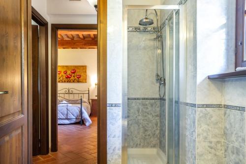 a bathroom with a shower and a bedroom at Casa Vacanza Il Carpignone 5 in Massa Marittima
