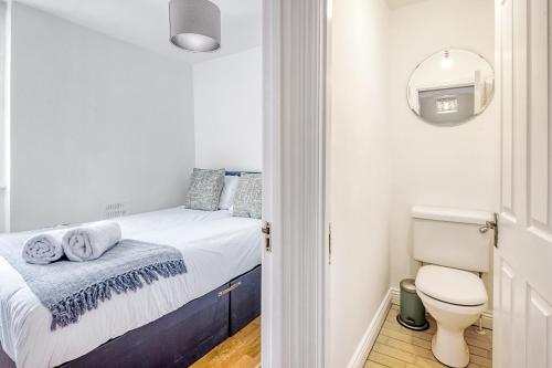 a small bedroom with a bed and a toilet at Marylebone Duplex Apartment in London