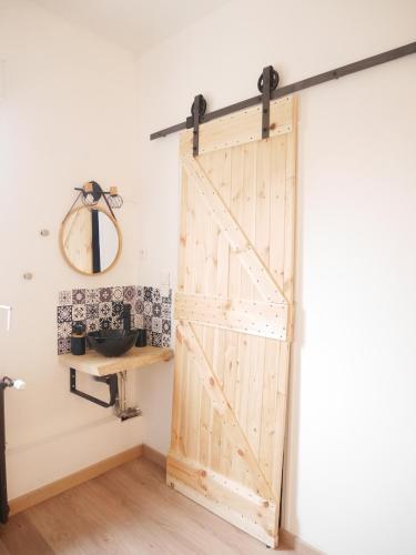 a sliding barn door in a room with a sink at Le Laurenti in Quérigut
