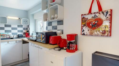 kuchnia z czerwonym urządzeniem na ladzie w obiekcie Studio avec parking Rue de la Semm w mieście Colmar