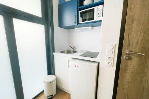 une petite cuisine avec un évier et un micro-ondes dans l'établissement #Y7 La Résidence Studio Caserne de Bonne Private residence, à Grenoble