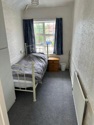 ein kleines Schlafzimmer mit einem Bett und einem Fenster in der Unterkunft Le Royal Residence 7 in London