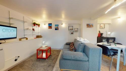 a living room with a blue couch and a tv at Studio avec parking Rue de la Semm in Colmar