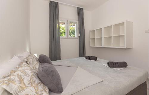 a white room with two beds and a window at 2 Bedroom Cozy Apartment In Zaboric in Zaboric