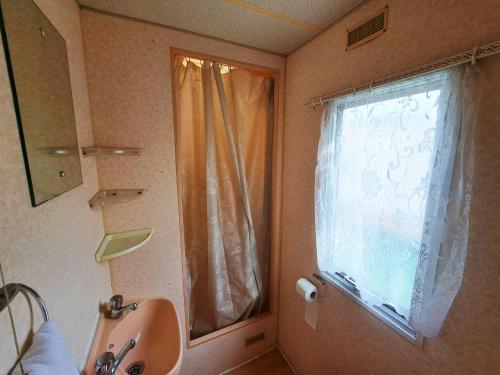 佐托爾的住宿－Pensjonat Łysa Góra，一间带水槽的浴室和一个带窗帘的窗户