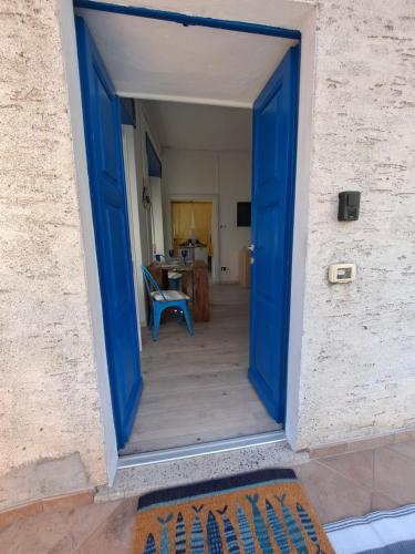 a blue door leading into a room with a table at Immobillario - Maison Felix in Gravedona
