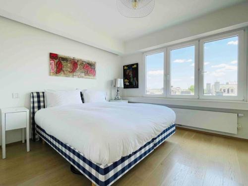 a white bedroom with a large bed and windows at Luxurious 1 bedroom in the Heart of City Center - 25 in Luxembourg