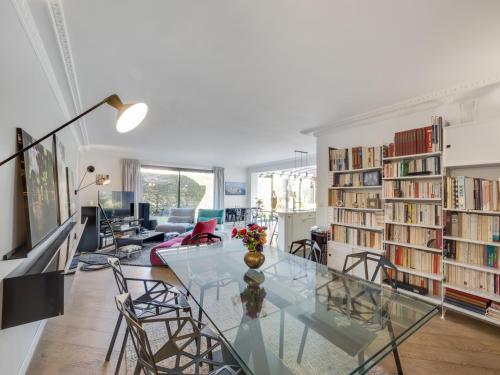 een woonkamer met een glazen tafel en boekenplanken bij Beau 4 pièces avec grand jardin et tennis in Jouy-en-Josas