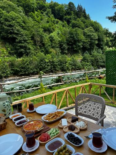 una mesa de madera con platos de comida. en Seyridere süit bungalov, en Çamlıhemşin