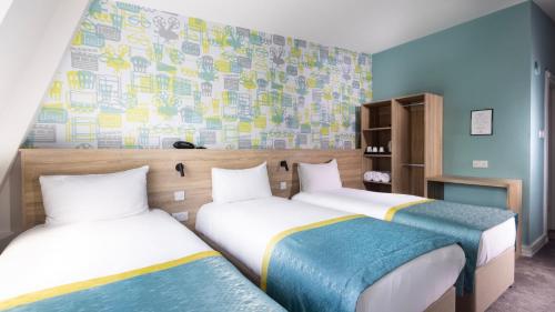 2 camas en una habitación con paredes azules en The Camden Street Hotel, en Dublín