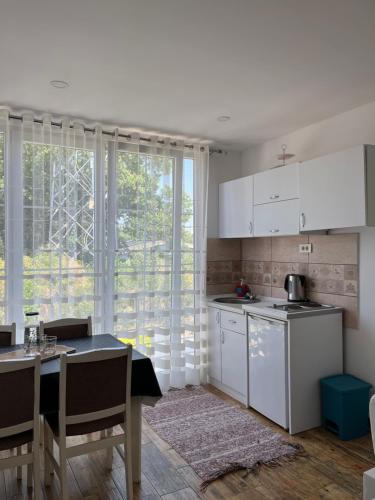 uma cozinha com armários brancos e uma mesa com uma sala de jantar em Demiri Rr em Ulcinj