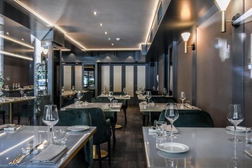 a dining room with tables and chairs and glasses at Sina De La Ville in Milan