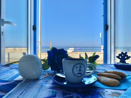 Una mesa con dos tazas de café y galletas. en Blue Velvet, en Punta Secca