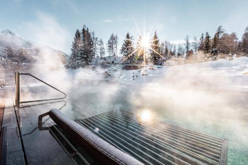 a hot spring with a bench in the snow at Hotel Klosterbräu in Seefeld in Tirol