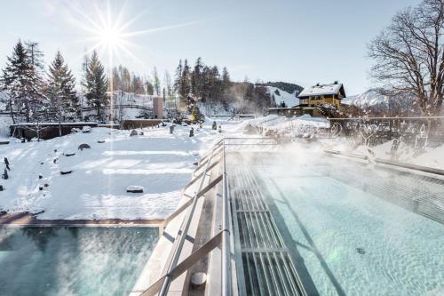 a swimming pool with snow on the ground at Hotel Klosterbräu in Seefeld in Tirol
