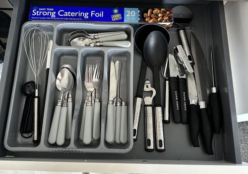 a drawer filled with utensils in a container at Courtyard Stay in Norwich