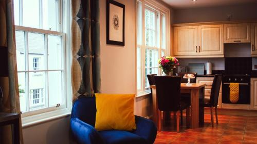 a living room with a blue chair and a table at Strawberry Fields Apartment in Strangford