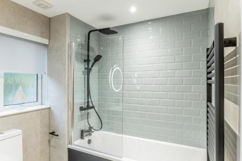 a bathroom with a shower and a bath tub at Stratheck Holiday Park in Dunoon