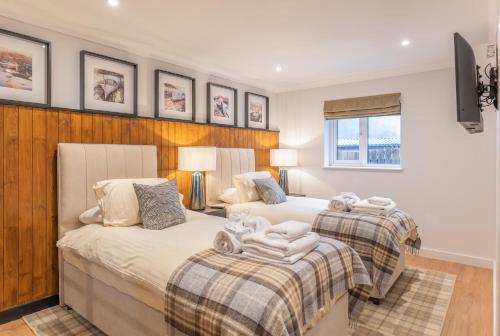 a bedroom with two beds and a tv at Stratheck Holiday Park in Dunoon