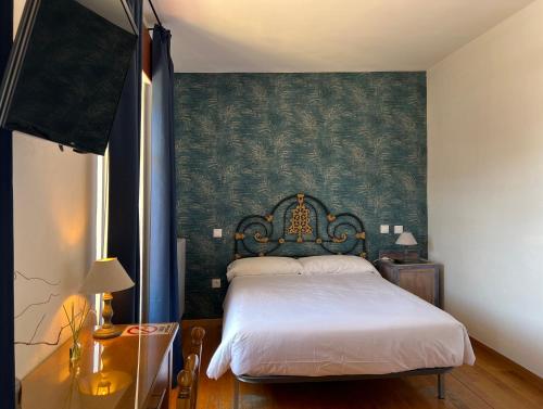 - une chambre avec un lit et un mur vert dans l'établissement Hostal La Trucha Sanabria, à Puebla de Sanabria