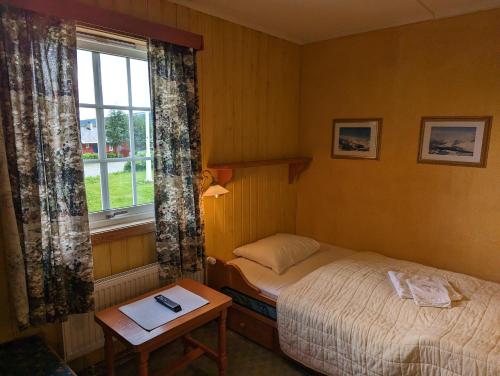 a small bedroom with two beds and a window at Grønolen Fjellgard in Beitostøl