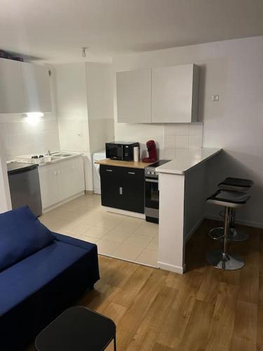 un salon avec un canapé et une cuisine dans l'établissement Logement Paris,Bas Montreuil Vincennes, à Montreuil