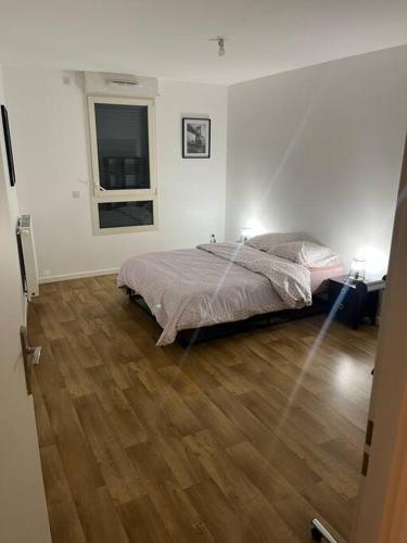 une chambre avec un lit et un parquet dans l'établissement Logement Paris,Bas Montreuil Vincennes, à Montreuil